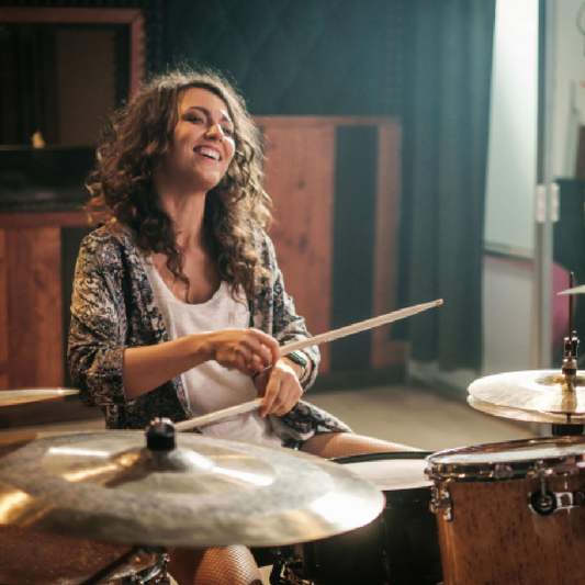 女性が楽しくドラムレッスンを受けている